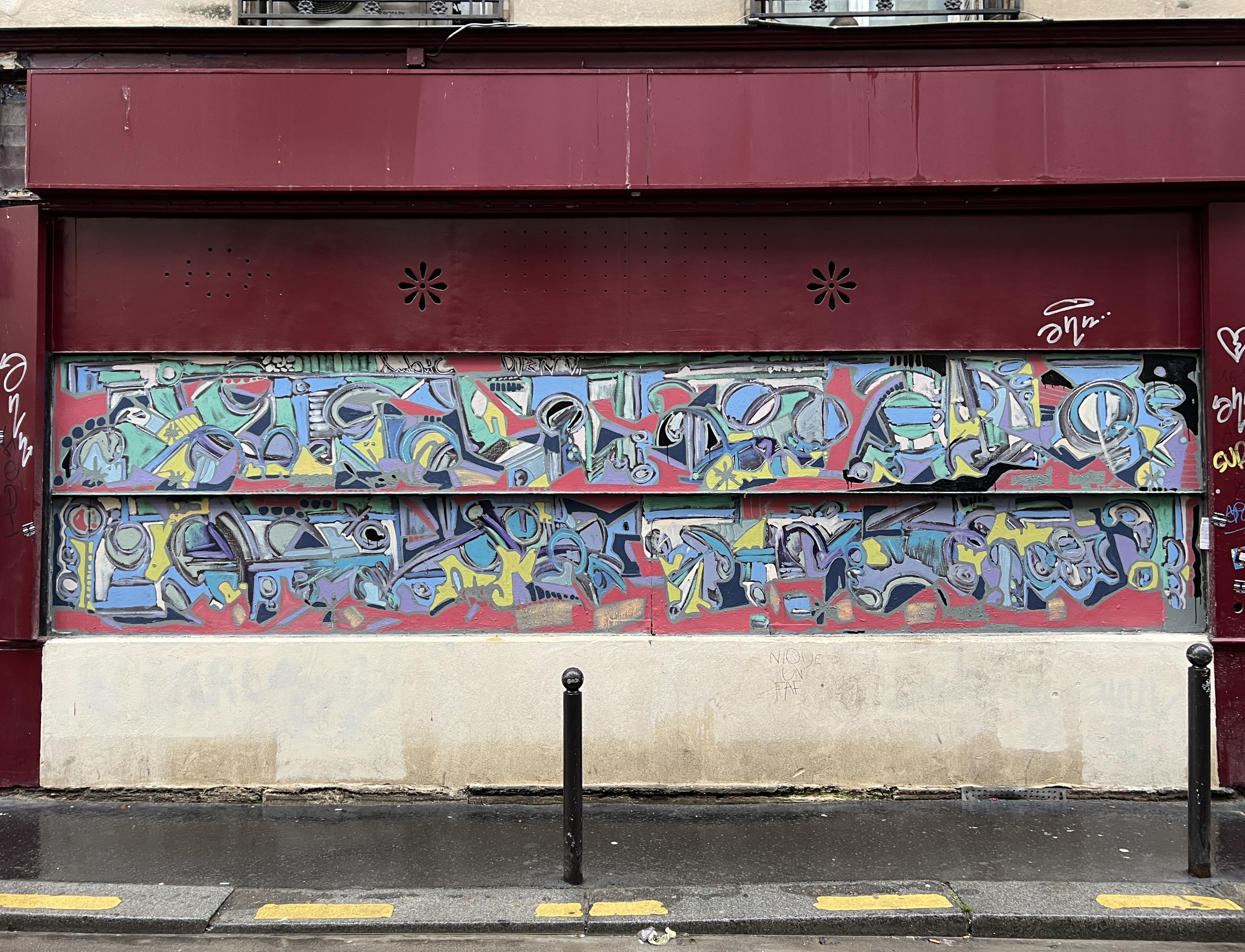 Maroon graffiti in Paris alleyway